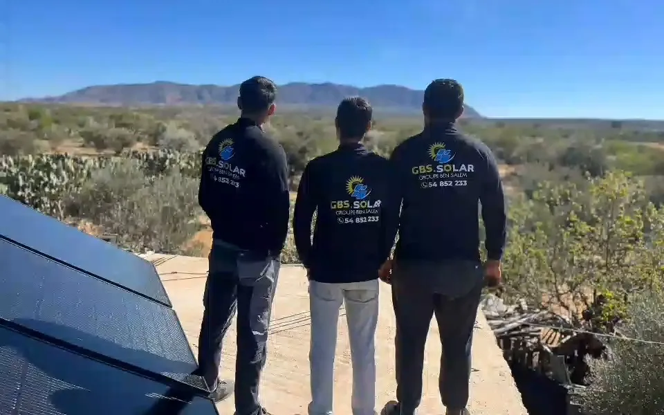 Trois techniciens de l'équipe, de dos, devant une installation terminée